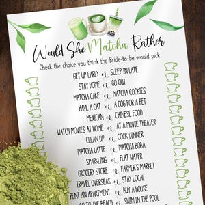 May include: A white paper game titled "Would She Matcha Rather" with matcha-themed illustrations. The game includes a list of choices for the bride-to-be. A pile of green matcha powder is in the lower left corner.