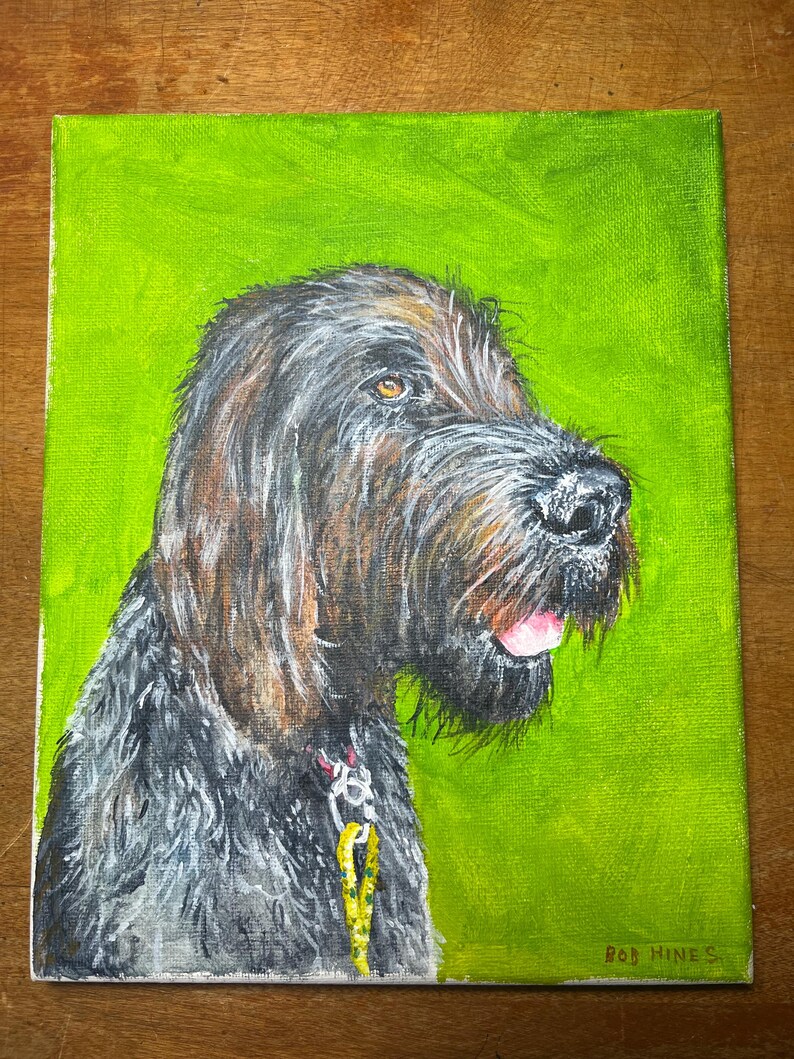 May include: A painting of a dog with a black and brown coat, looking to the right. The dog has a pink tongue sticking out and is wearing a collar with a yellow leash. The painting is on a green background and signed "Bob Hines".