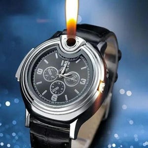 May include: A silver and black wristwatch with a black leather band. The watch has a built-in lighter with a flame coming out of the top.