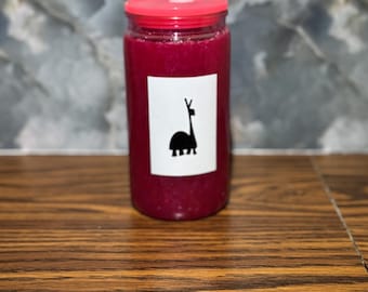 以下が含まれることがあります： 赤い蓋が付いた円筒形のガラス瓶で、濃いマゼンタ色の液体で満たされています。黒いラマのシルエットが入った白いラベルが瓶に貼られています。瓶は木製の表面に置かれています。