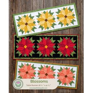 May include: Three rectangular table runners featuring a star-shaped floral pattern. The top runner has yellow flowers on white, the middle has red flowers on black, and the bottom has peach flowers on white. Each measures 41.9 cm by 105.4 cm.
