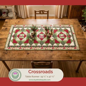May include: A rectangular table runner featuring a geometric patchwork design in red, green, and cream fabric. The pattern includes star motifs and central squares with small illustrations. It measures 19.5 inches by 47.5 inches as labeled.