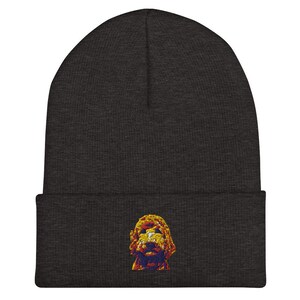 May include: A dark gray beanie with a yellow, orange, and red embroidered image of a dog's head.