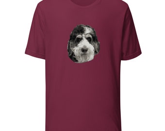 May include: A maroon t-shirt featuring a black and white image of a dog's face on the front.