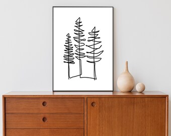 May include: A black and white line drawing of three trees in a minimalist style. The drawing is framed and hanging on a white wall above a wooden dresser.