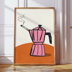May include: A framed art print featuring a pink coffee maker with a cigarette in its spout, emitting smoke. The illustration is set against a cream background with an orange base, all within a wooden frame. The artwork has a whimsical, hand-drawn style.