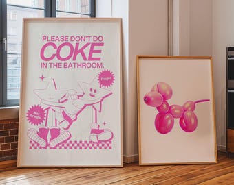 May include: Two framed posters with pink illustrations. The left poster has a pink cartoon image of two stars holding a person with the text "Please don't do coke in the bathroom." The right poster has a pink balloon animal shaped like a dog.