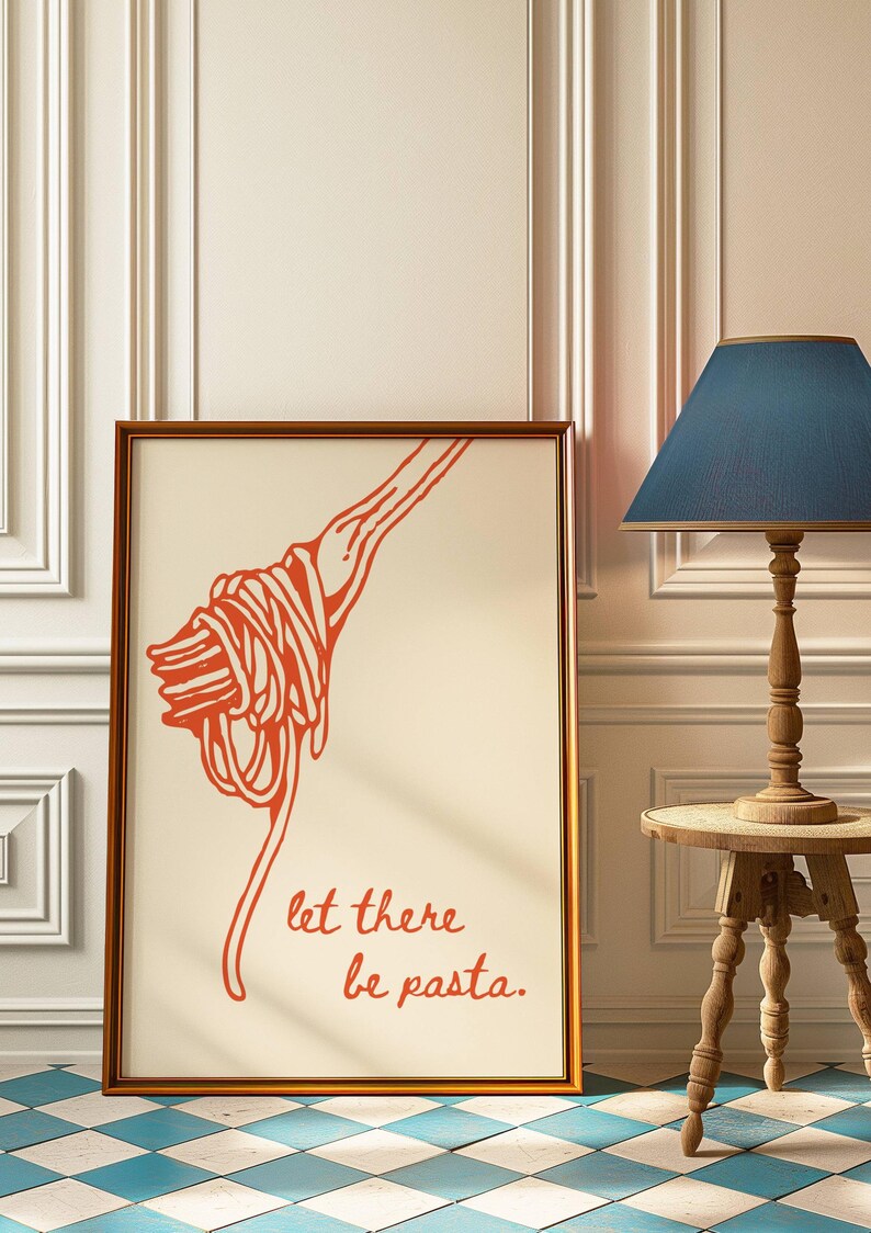 May include: A framed print with a red illustration of a fork twirling spaghetti. The text "let there be pasta." is written below the illustration.
