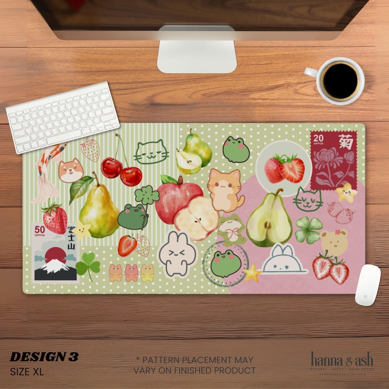 May include: XL mouse pad with a whimsical design featuring fruits, animals, and Japanese-inspired elements. The pad has a green and pink background with illustrations of pears, strawberries, cats, and frogs. The text "DESIGN 3" and "SIZE XL" are visible.
