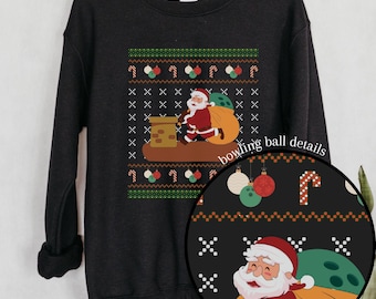 May include: Black Christmas sweater with a Santa Claus bowling a bowling ball down a chimney. The sweater has a repeating pattern of candy canes, ornaments, and bowling balls. The text "bowling ball details" is written in white on a black circle.