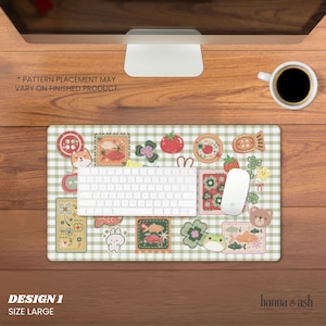May include: A large mousepad with a green and white checkered pattern and various colorful patches featuring a Shiba Inu, strawberries, and other cute illustrations. A white keyboard and mouse are on the pad. The text "DESIGN 1 SIZE LARGE" is visible.