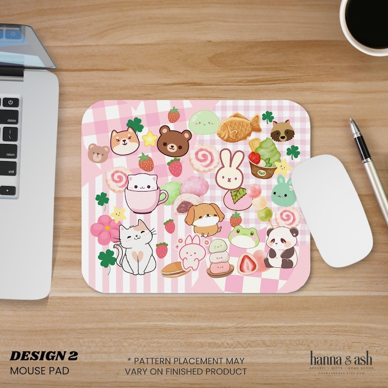Pu&ograve; includere: Un tappetino per mouse rosa con un motivo a quadri vichy rosa e bianco e strisce verticali. Il tappetino presenta simpatiche illustrazioni di cartoni animati di animali, dessert e fragole. Il testo "DESIGN 2" e "MOUSE PAD" &egrave; in basso.