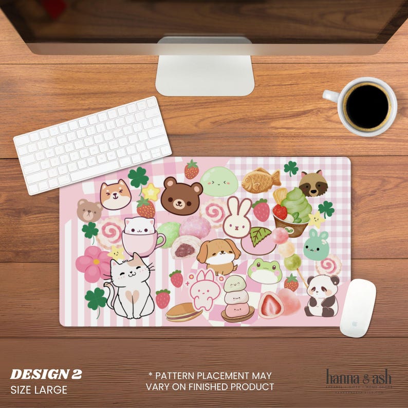 Pu&ograve; includere: Un grande tappetino per mouse rosa con un design kawaii con vari animali dei cartoni animati, cibi e accenti di trifoglio. Il tappetino per mouse ha uno sfondo a righe e il testo "DESIGN 2 SIZE LARGE".