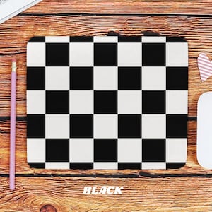 May include: Black and white checkered mouse pad with the word "BLACK" printed on the wooden surface below it.