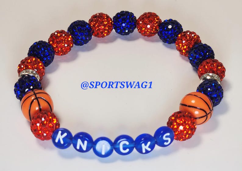 Handmade sparkly bracelet set featuring orange and blue crystal-encrusted beads with mini basketball charms and "NY KNICKS" letter beads, designed for fans of the New York Knicks basketball team perfect for game day, team spirit, and gifting. Custom colors available.