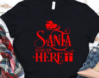 May include: Black t-shirt with red text that says "Santa Please Stop Here" with a red illustration of Santa in a sleigh above the text.