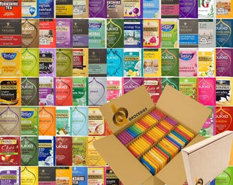May include: A large cardboard box filled with an assortment of colourful tea bags, featuring various brands and flavours. The box is labelled with the text "BA GROCERIES" and contains rows of individually wrapped tea bags in a wide spectrum of colours.