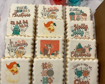 May include: Nine square-shaped Christmas cookies with various festive designs. The cookies feature illustrations of Santa Claus, reindeer, Christmas trees, and holiday greetings like "Tis the Season" and "Holly Jolly."