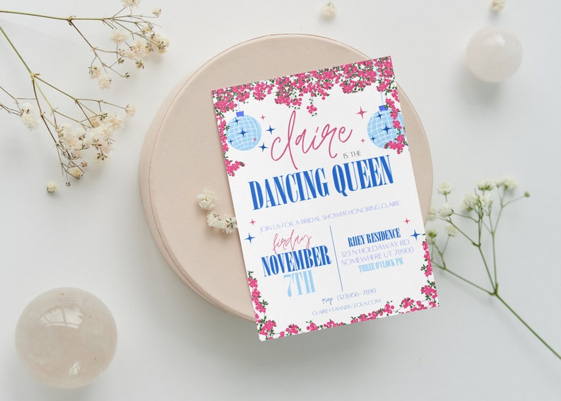Op de afbeelding: Een witte uitnodiging met roze bloemen en blauwe discoballen. De tekst luidt "Claire is de danskoningin" en bevat de datum "Vrijdag 7 november".