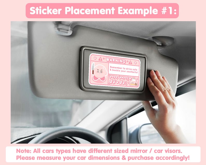 Puede incluir: Una pegatina para visera de coche rosa y blanca con un personaje de dibujos animados y el texto "WARNINGA Remember to drive safe & buckle your seatbelts!"