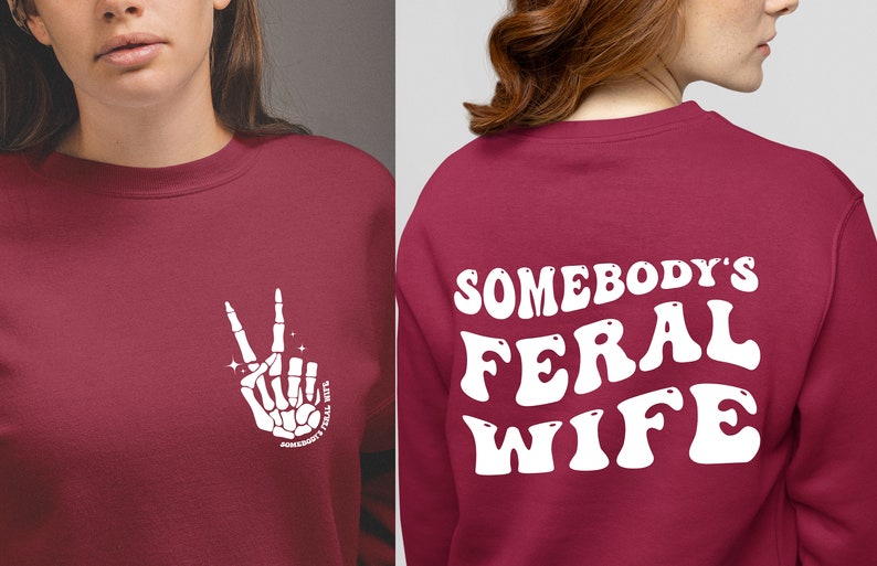 May include: A maroon sweatshirt with a white skeleton hand making a peace sign on the front and the text "Somebody's Feral Wife" in white on the back.