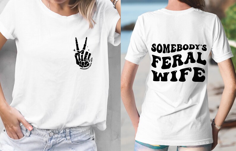 May include: White t-shirt with a black skeleton hand making a peace sign on the front and the text "Somebody's Feral Wife" in black on the back.