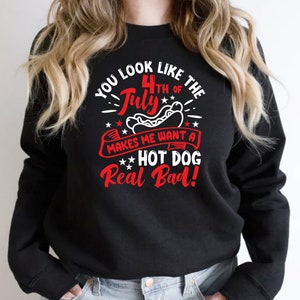 May include: Black sweatshirt with a red, white, and blue graphic. The graphic reads "You look like the 4th of July makes me want a hot dog real bad!" The design includes stars and a hot dog.