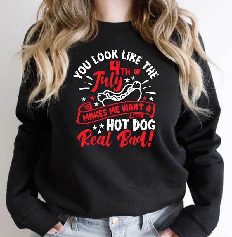 May include: Black sweatshirt with a red, white, and blue graphic. The graphic reads "You look like the 4th of July makes me want a hot dog real bad!" The design includes stars and a hot dog.