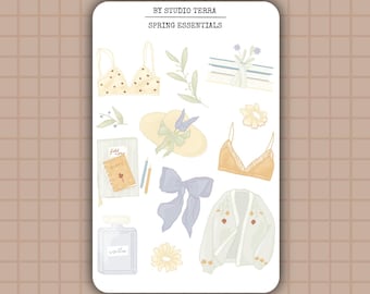 Pode incluir: Uma folha de adesivos com tema primaveril. Os adesivos apresentam uma variedade de itens, incluindo um chapéu, um sutiã, um cardigã, um livro, um frasco de perfume, um girassol e um laço. O texto "BY STUDIO TERRA SPRING ESSENTIALS" está no topo da folha.
