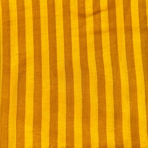 Op de afbeelding: Een gevouwen textiel met verticale strepen in tinten geel en bruin. De stof is rechthoekig en lijkt gemaakt van een lichtgewicht materiaal. De strepen zijn gelijkmatig verdeeld en lopen over de lengte van de stof. Het textiel is waarschijnlijk een sjaal of een vergelijkbaar accessoire.
