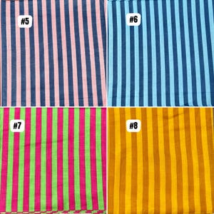Op de afbeelding: Vier stoffstalen met verticale strepen in verschillende kleurencombinaties. De stalen zijn genummerd. De kleuren zijn onder meer roze en marineblauw, lichtblauw, roze en groen en tinten geel en oranje.
