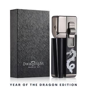May include: A black and silver lighter with a dragon design and a built-in cigarette holder. The lighter is in a black box with the text "Draglight Smoking Set".