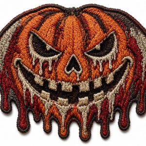 May include: An embroidered patch featuring a jack-o'-lantern with a menacing expression, sharp teeth, and triangular eyes. The pumpkin is orange with dark brown outlines, and features a dripping effect in shades of red, cream, and brown.