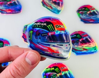 Puede incluir: Una pegatina holográfica de un casco de carreras con un logotipo de Monster Energy, el número 33 y las palabras "Abby" y "Android".