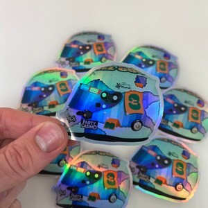 Peut inclure: Un ensemble de six autocollants holographiques irisés représentant une voiture de course de dessin animé avec le numéro 3 et les mots "Party Casino" et "Huski Chocolate".
