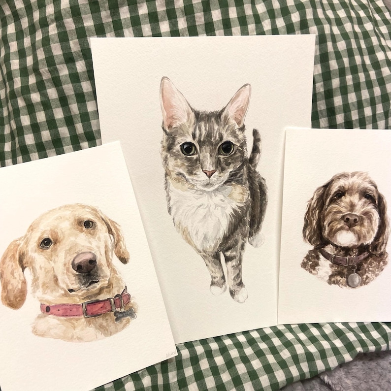 May include: Three watercolor paintings of pets. A brown and white cat, a golden retriever, and a brown and white dog.