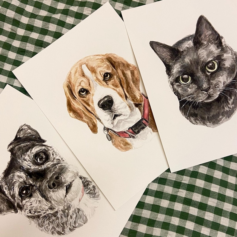 May include: Three watercolor paintings of pets. The first painting is of a black cat with green eyes. The second painting is of a brown and white beagle. The third painting is of a black and gray schnauzer.