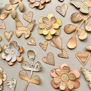 24+ Piece, Hand Painted Flowers, Butterflies And Hearts. Handmade embellishments cut from a master board made from authentic vintage papers.