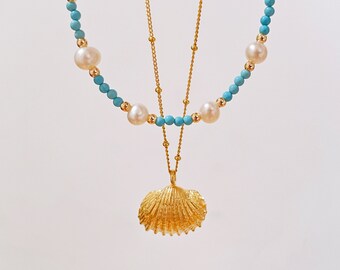 May include: A gold necklace with a seashell pendant. The necklace is made of turquoise and white beads and a delicate gold chain.