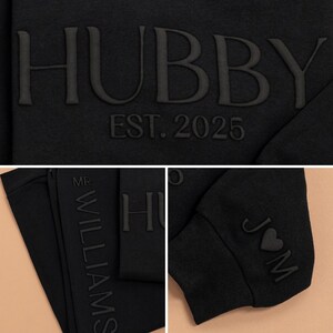 May include: Black sweatshirt with the text "HUBBY EST. 2025" on the front and "MR. WILLIAMS" on the side. The sleeve has the text "J&M" with a heart symbol.