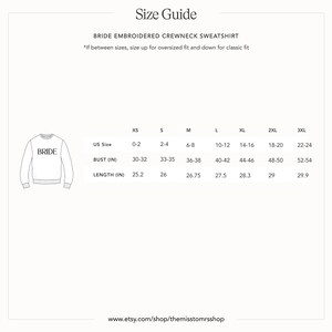 以下が含まれることがあります： 前面に「BRIDE」の文字が刺繍された白いクルーネックのスウェットシャツ。画像には、XSから3XLまでのサイズのバストと長さの測定値がcmで記載されたサイズガイドが含まれています。ウェブサイトのアドレスも表示されています。