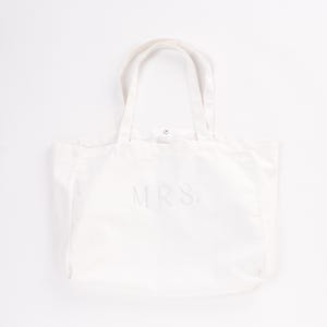 Peut inclure: Sac fourre-tout en toile blanche avec le mot "MRS." brod&eacute; en blanc sur le devant.