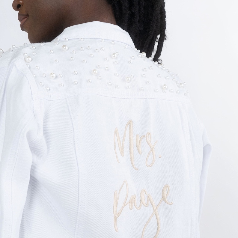 Personalized bridal denim jacket. Made from soft denim and decorated with faux pearls for a chic look. White jean jacket custom embroidered with your name. Perfect to wear for an engagement photoshoot.