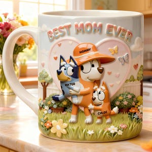 May include: A ceramic mug with the words "BEST MOM EVER" in raised letters. The mug features a 3D design of cartoon characters hugging, with names "MATEO" and "CHLOE". The character labeled "MOMMY" wears an orange hat. The mug is decorated with flowers.