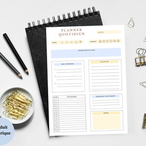 Peut inclure: Un planificateur quotidien imprimable avec des sections pour les listes de tâches, les priorités, l'horaire, les notes et une affirmation du jour. Le planificateur a un schéma de couleurs bleu clair et jaune.