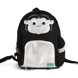 May include: Black backpack with a silver front pocket and a monkey face with googly eyes. The backpack has a tag that says "playgrooved".