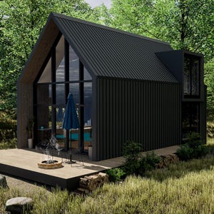 Puede incluir: Una moderna cabaña negra con techo inclinado y grandes ventanales, situada en una zona boscosa. Cuenta con una terraza de madera, una sombrilla azul y una pequeña barbacoa, lo que sugiere un espacio exterior relajante.