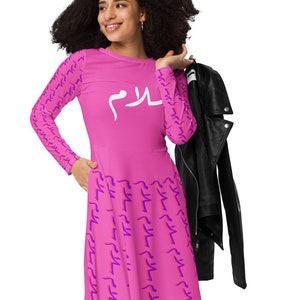 May include: A pink long-sleeved dress with a white Arabic word "Salam" printed on the front. The dress has a purple pattern of the word "Salam" repeated throughout.