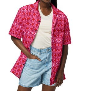 May include: A woman wearing a pink and white patterned button-down shirt with short sleeves and light blue denim shorts.