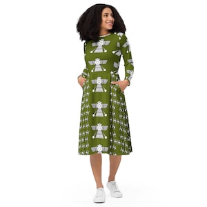 May include: A green midi dress with a white pattern of stylized winged figures. The dress has long sleeves and a round neckline.